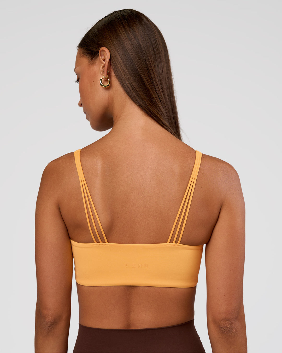 Woman wearing Peaches Wrap Sports Bra - Warm Apricot | Model:Brylee | Size:XS - view 2