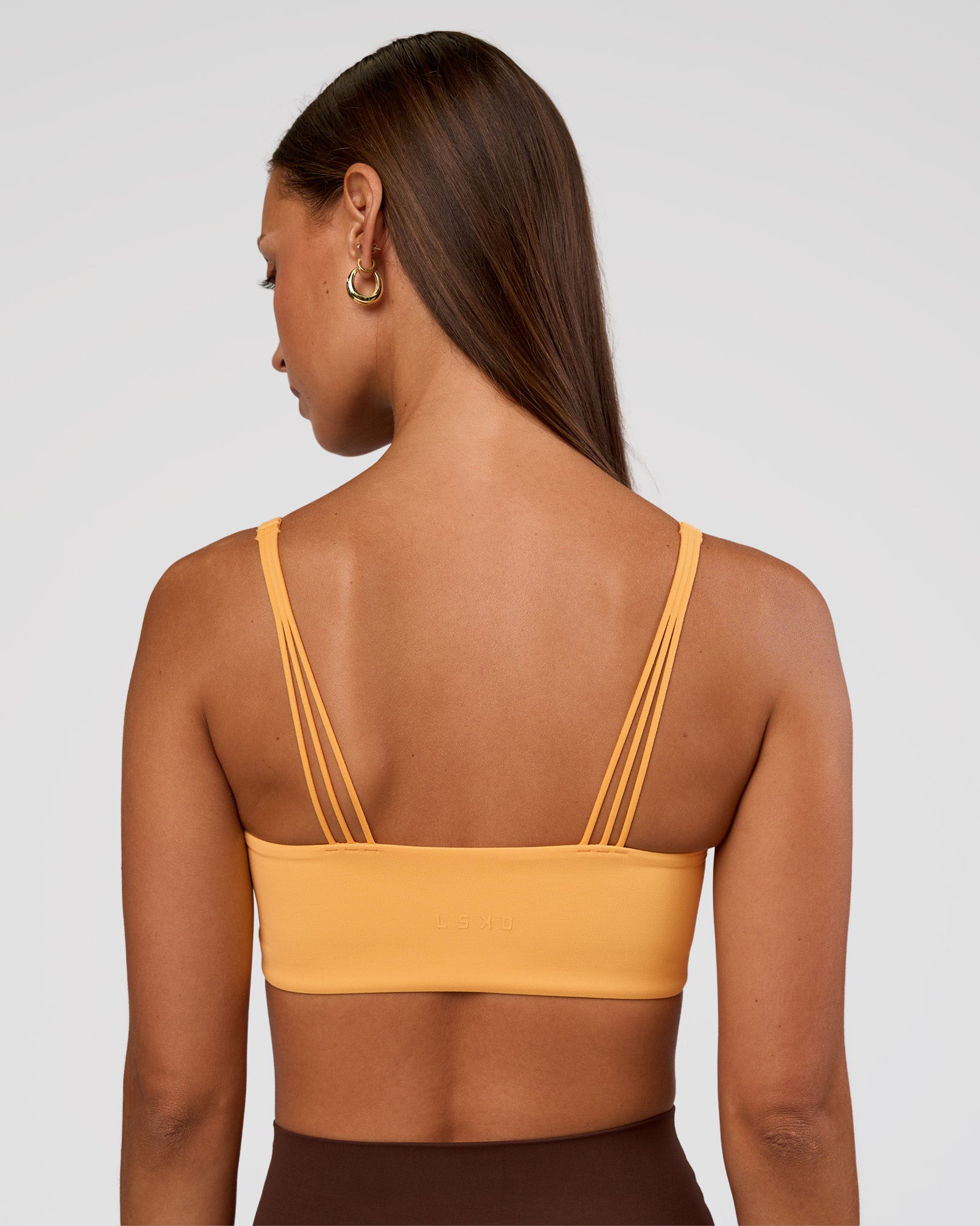 Woman wearing Peaches Wrap Sports Bra - Warm Apricot | Model:Brylee | Size:XS