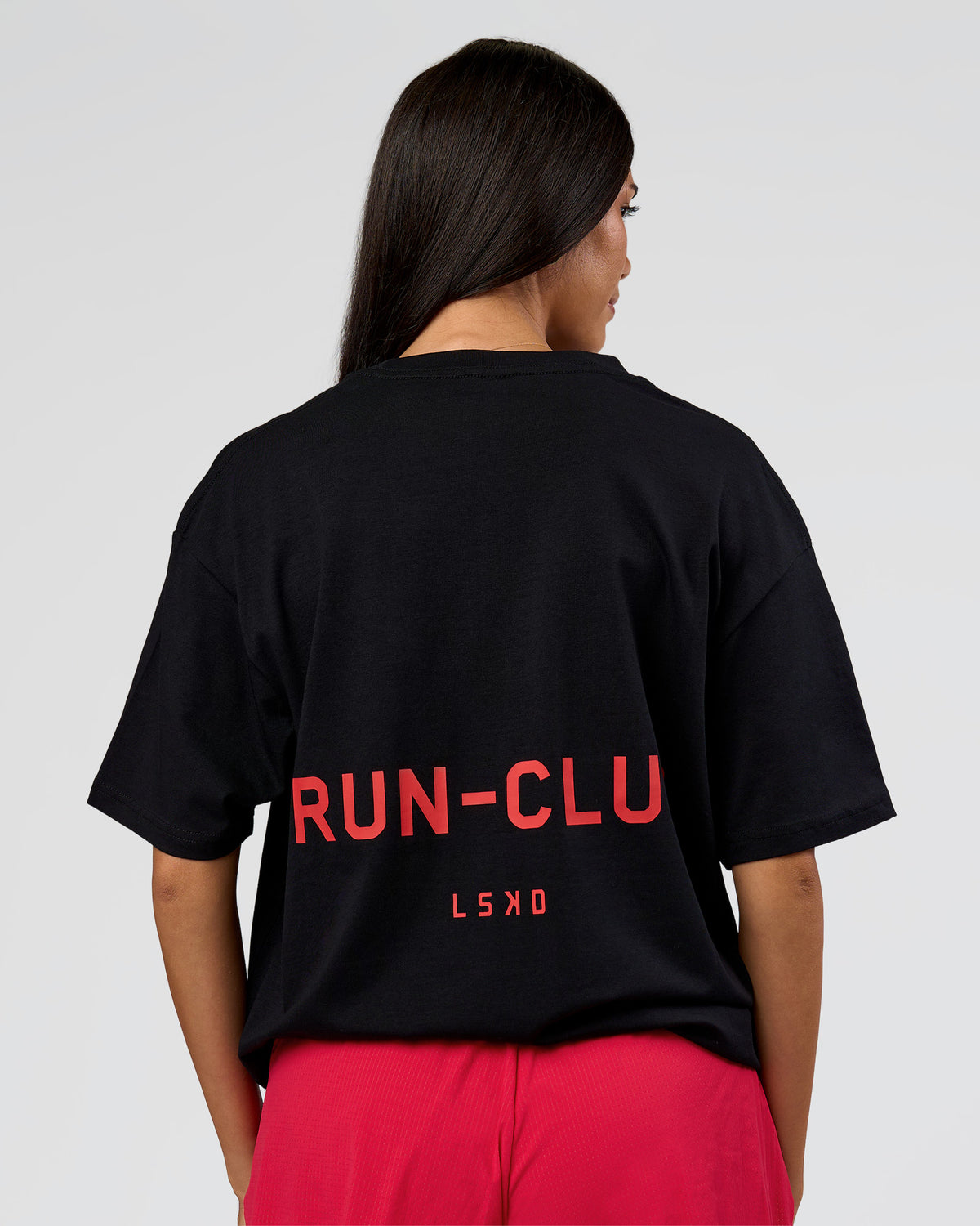Woman wearing RUN CLUB FLXCotton Tee Oversize - Black-Scarlet | Model:Rhiley | Size:XS