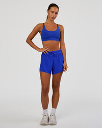 Woman wearing Rapid Sports Bra - Electric Indigo | Model:Brylee | Size:XS | Thumbnail Index: 3