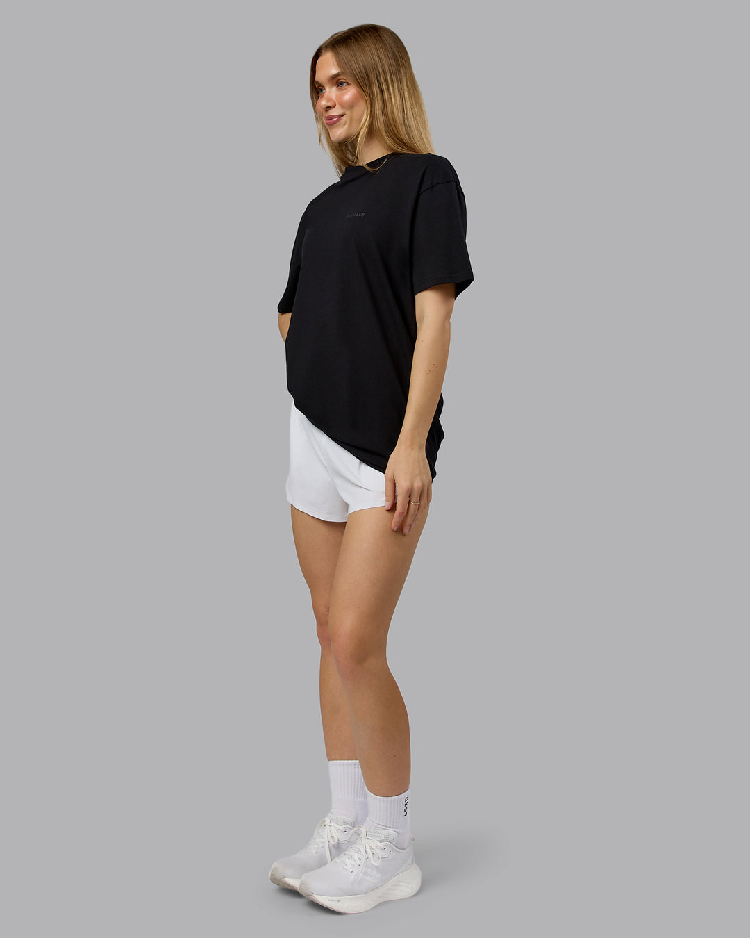 Woman wearing RUN CLUB FLXCotton Tee Oversize - Black-Reflective | Model:Emilie | Size:XS - view 9