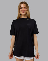 Woman wearing RUN CLUB FLXCotton Tee Oversize - Black-Reflective | Model:Emilie | Size:XS | Thumbnail Index: 3
