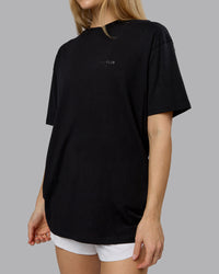 Woman wearing RUN CLUB FLXCotton Tee Oversize - Black-Reflective | Model:Emilie | Size:XS | Thumbnail Index: 9