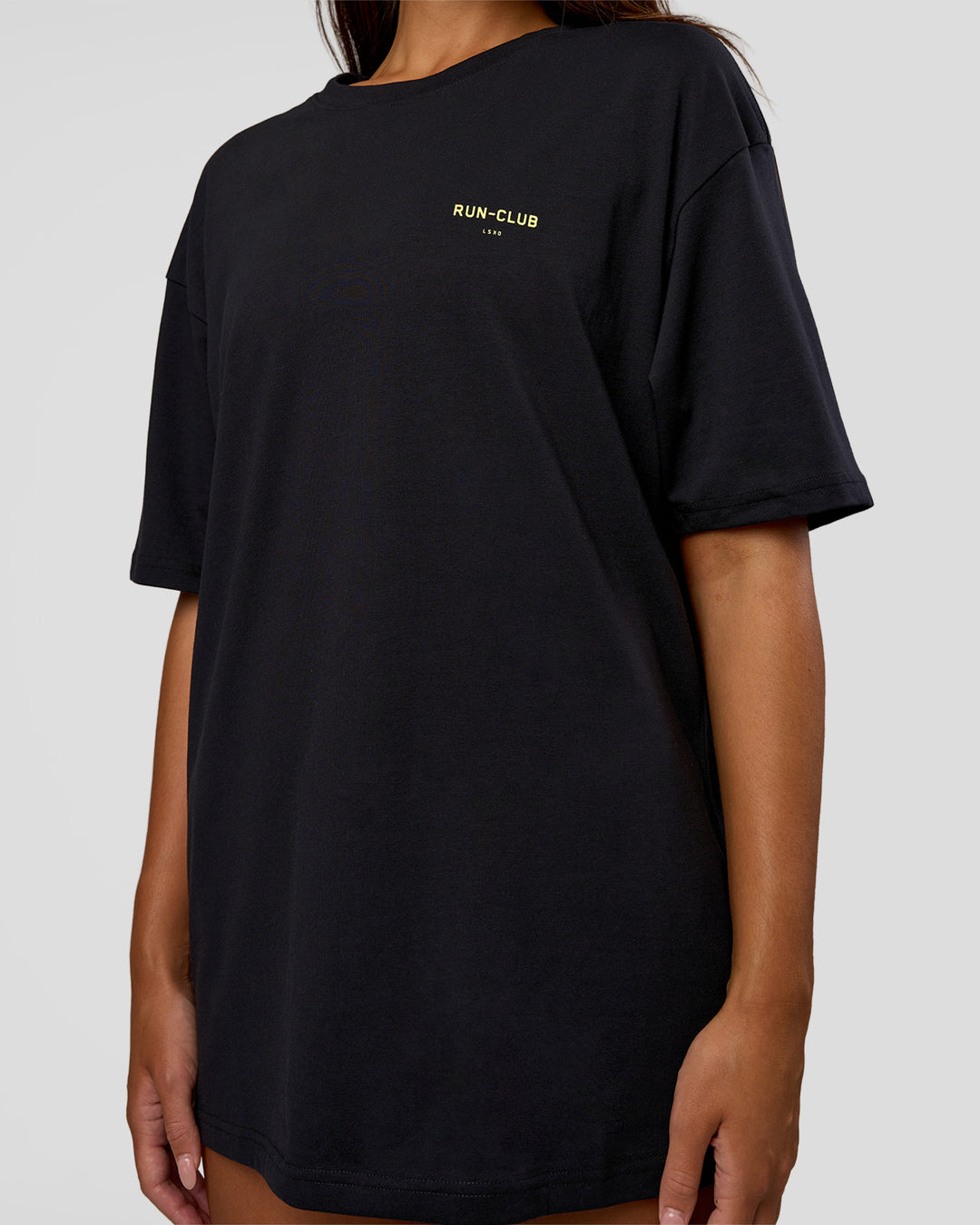 Woman wearing RUN CLUB FLXCotton Tee Oversize - Black-Yellow Fizz | Model:Kirstyn | Size:XS - view 10