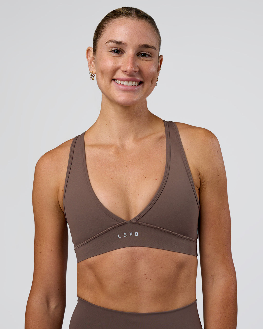 Woman wearing Stamina Sports Bra - Peppercorn | Set:true | Angle:front | Model:Emelia | Size:XS - view 1