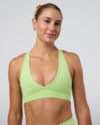 Woman wearing Stamina Sports Bra - Solar Lime | Set:true | Angle:front | Model:Emelia | Size:XS | Thumbnail Index: 0