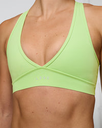 Woman wearing Stamina Sports Bra - Solar Lime | Set:true | Angle:closeup | Model:Emelia | Size:XS | Thumbnail Index: 5