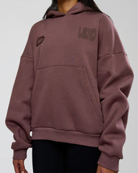 Woman wearing Static Grit Unisex Boxy Hoodie - Cocoa Powder-Hot Chocolate | Model:Loren | Size:XS | Thumbnail Index: 8