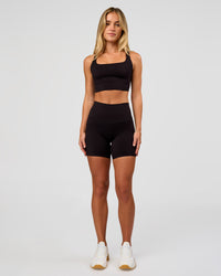 Woman wearing Twist Long Line Sports Bra in Black | Model:Issy | Size:XS | Thumbnail Index: 2