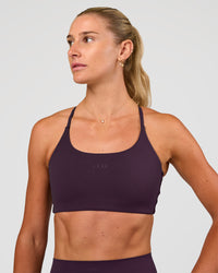 Woman wearing Twist Sports Bra - Midnight Plum | Model:Emelia | Size:XS | Thumbnail Index: 1