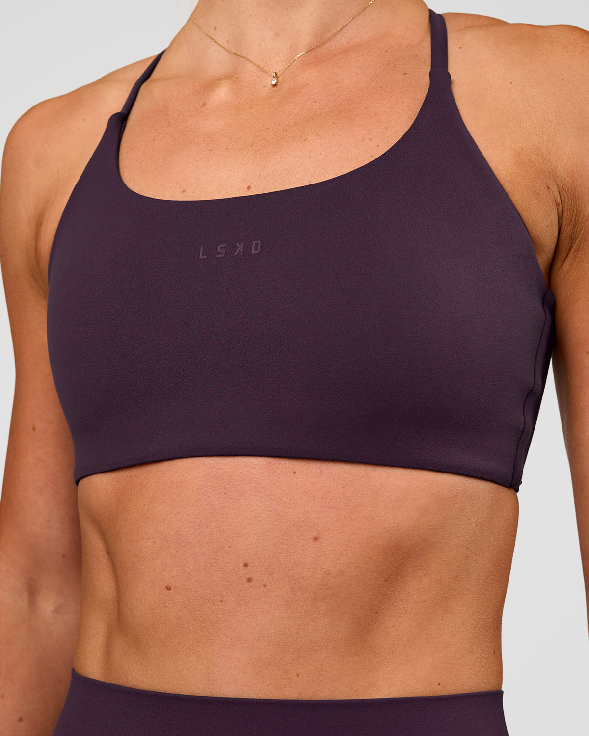 Woman wearing Twist Sports Bra - Midnight Plum | Model:Emelia | Size:XS - view 1
