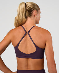 Woman wearing Twist Sports Bra - Midnight Plum | Model:Emelia | Size:XS | Thumbnail Index: 2