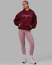 Woman wearing Unisex 1% Better Hoodie Oversize - Cranberry-White | Thumbnail Index: 8