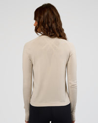 Woman wearing AeroFLX+ Long Sleeve Half Zip - Shale Beige/Shale Beige | Model:Dakota | Size:XS | Thumbnail Index: 2