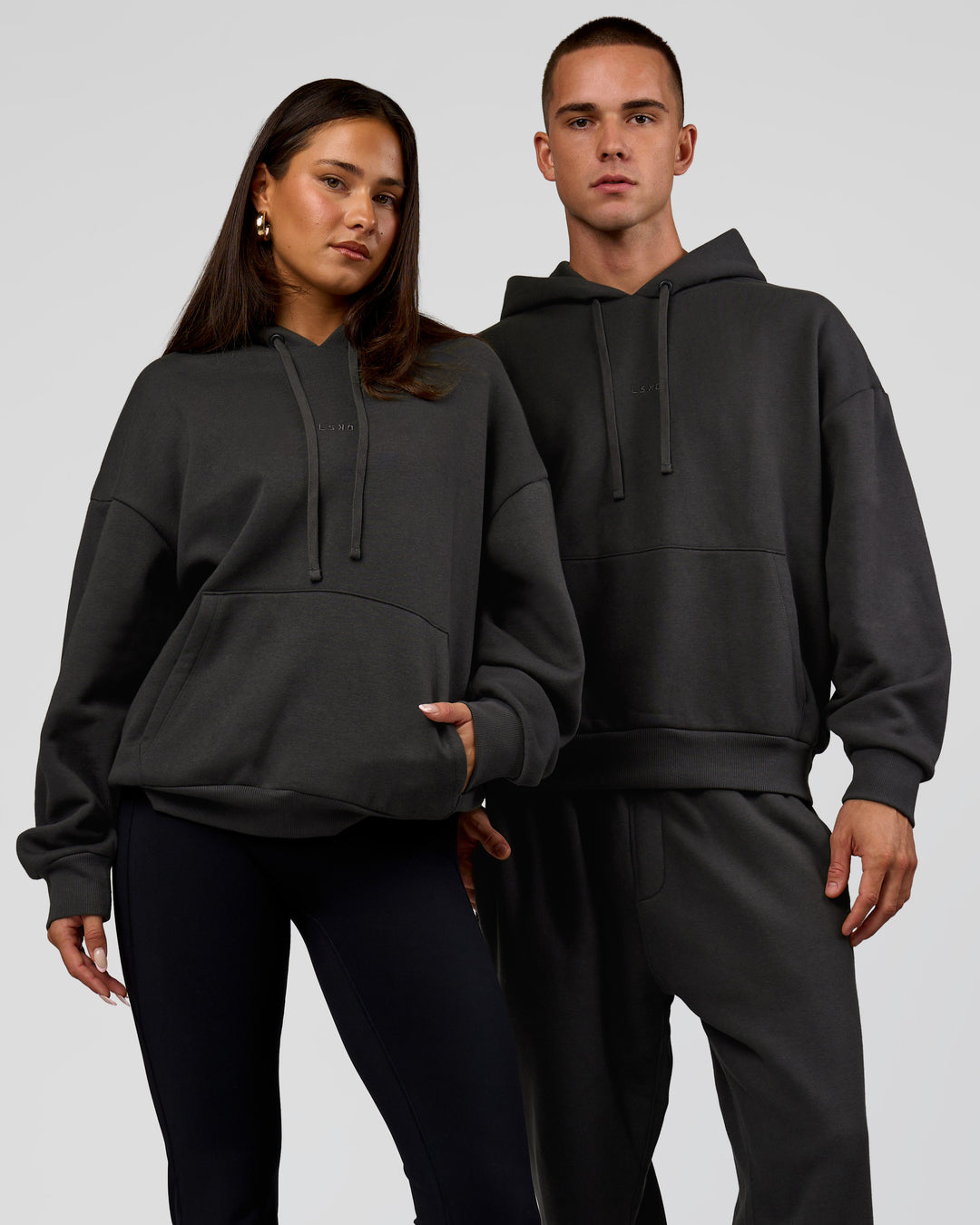 Duo wearing Base Oversized DC Hoodie - Onyx | Model:Albert | Size:M | Model:Bianca | Size:XS - view 1