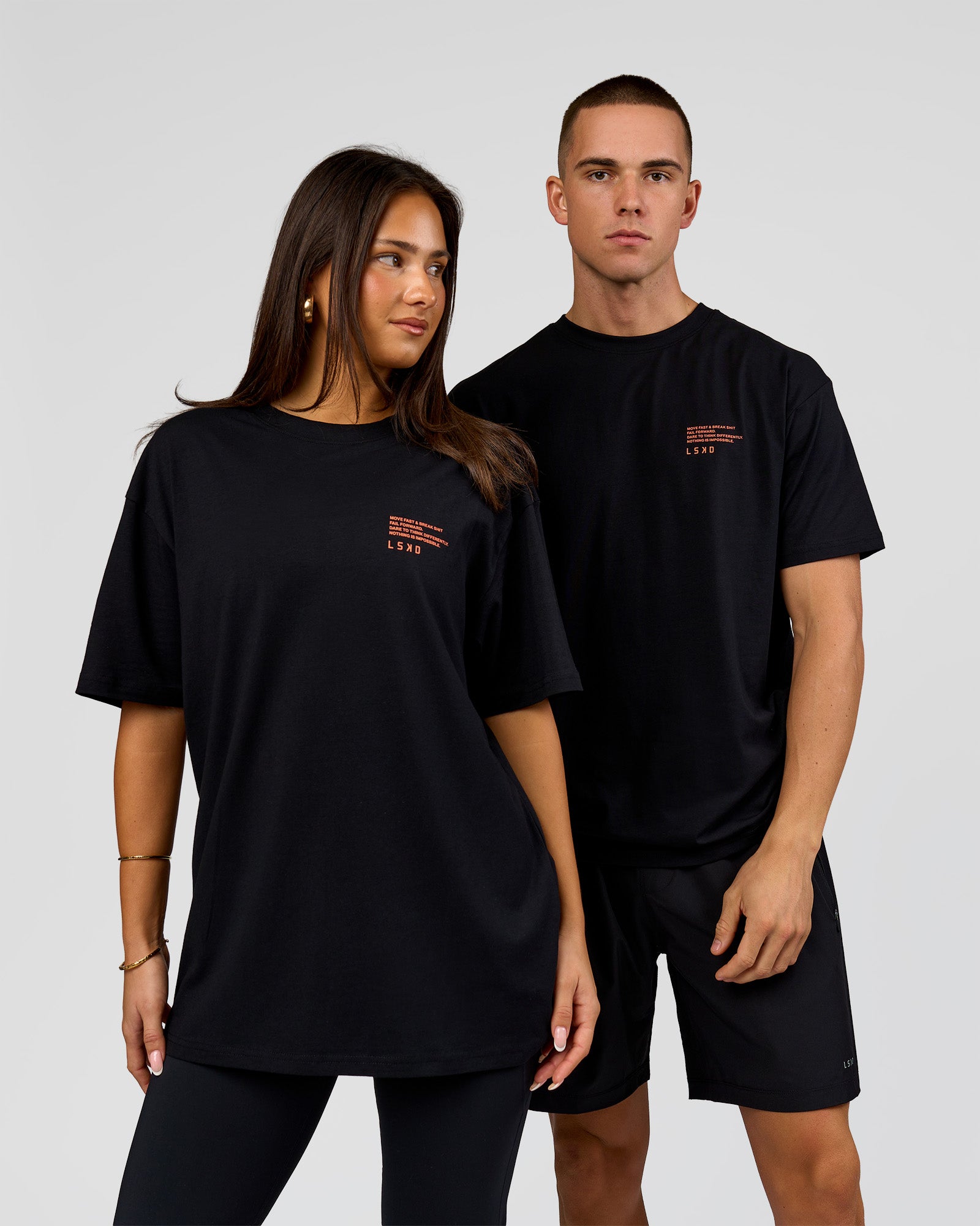 Duo wearing Coffee Run FLXCotton Oversized Tee - Black-Ultra Orange | Model:Albert | Size:M | Model:Bianca | Size:XS
