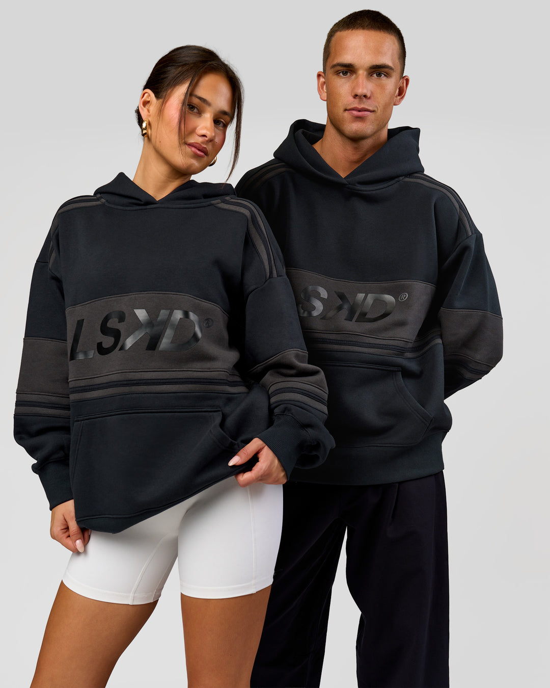 Duo wearing A-Team Oversized Hoodie - Caviar-Onyx | Model:Bianca | Size:XS | Model:Albert | Size:M - view 1