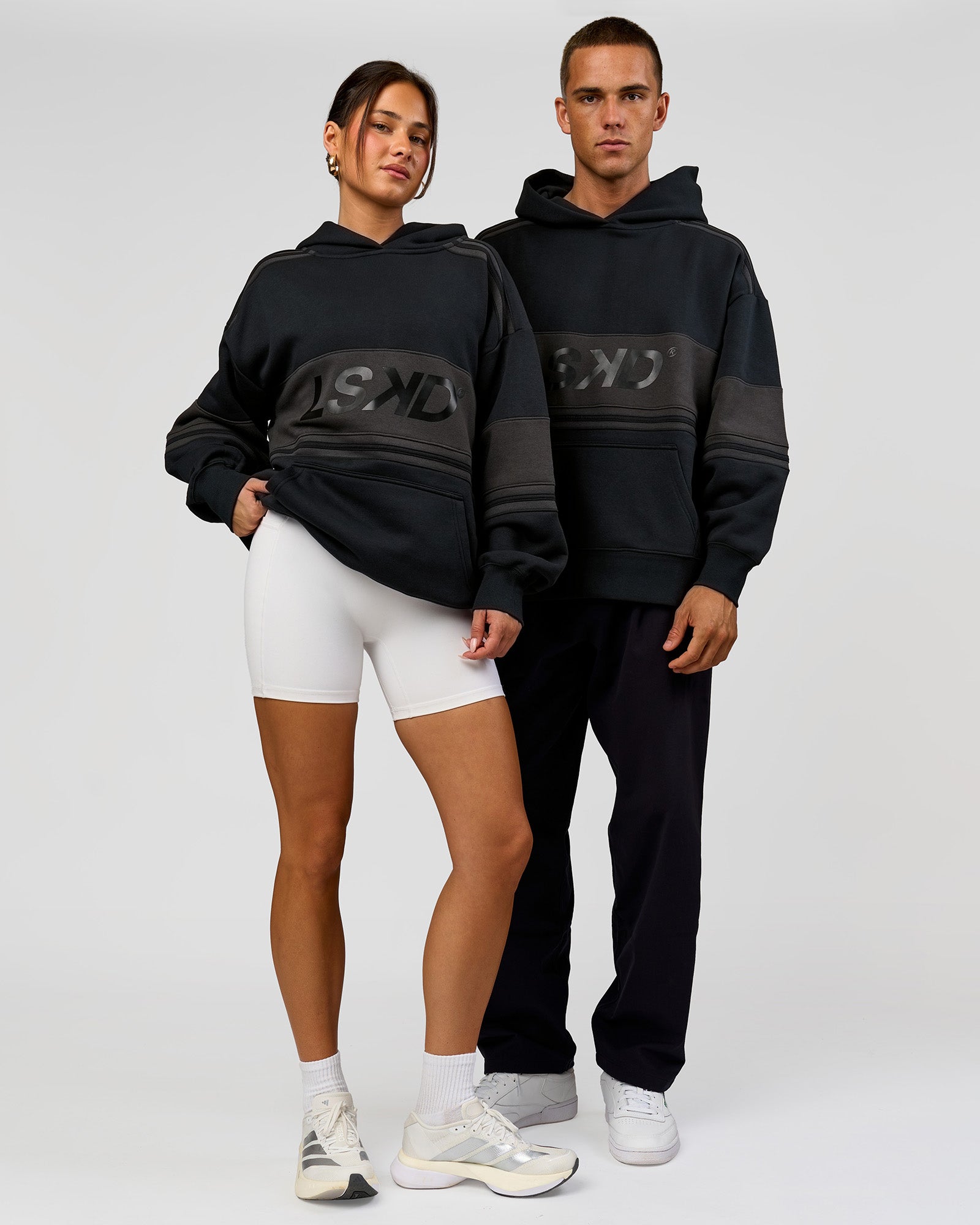 Duo wearing A-Team Oversized Hoodie - Caviar-Onyx | Model:Bianca | Size:XS | Model:Albert | Size:M