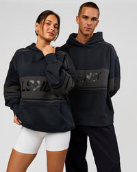 Duo wearing A-Team Oversized Hoodie - Caviar-Onyx | Model:Bianca | Size:XS | Model:Albert | Size:M | Thumbnail Index: 2