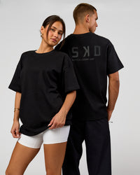Duo wearing Tonal Legacy Heavyweight Oversized Tee - Black-Black | Model:Bianca | Size:XS | Model:Albert | Size:M | Thumbnail Index: 0