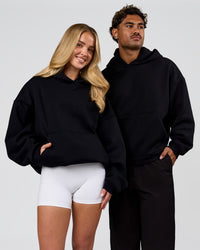 Duo wearing Tonal Legacy Boxy Hoodie - Black-Black | Model:Issy | Size:XS | Model:Xav | Size:L | Thumbnail Index: 6