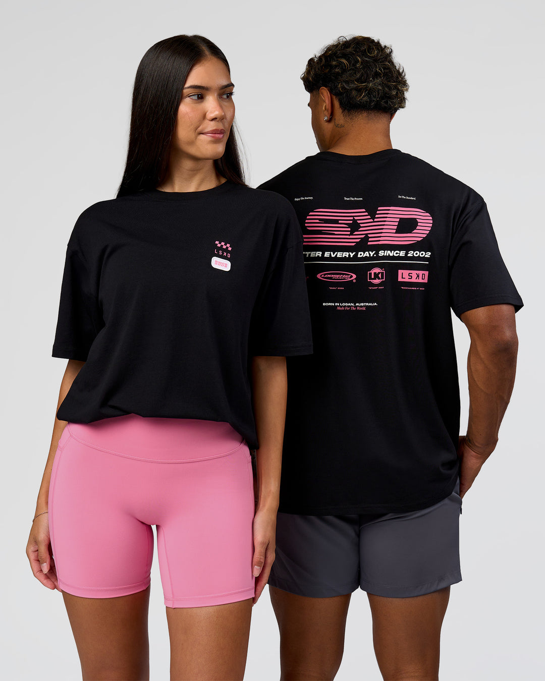 Duo wearing Archive FLXCotton Oversized Tee - Black-Candy Pink | Model:Rhiley | Size:XS | Model:Xav | Size:L - view 1