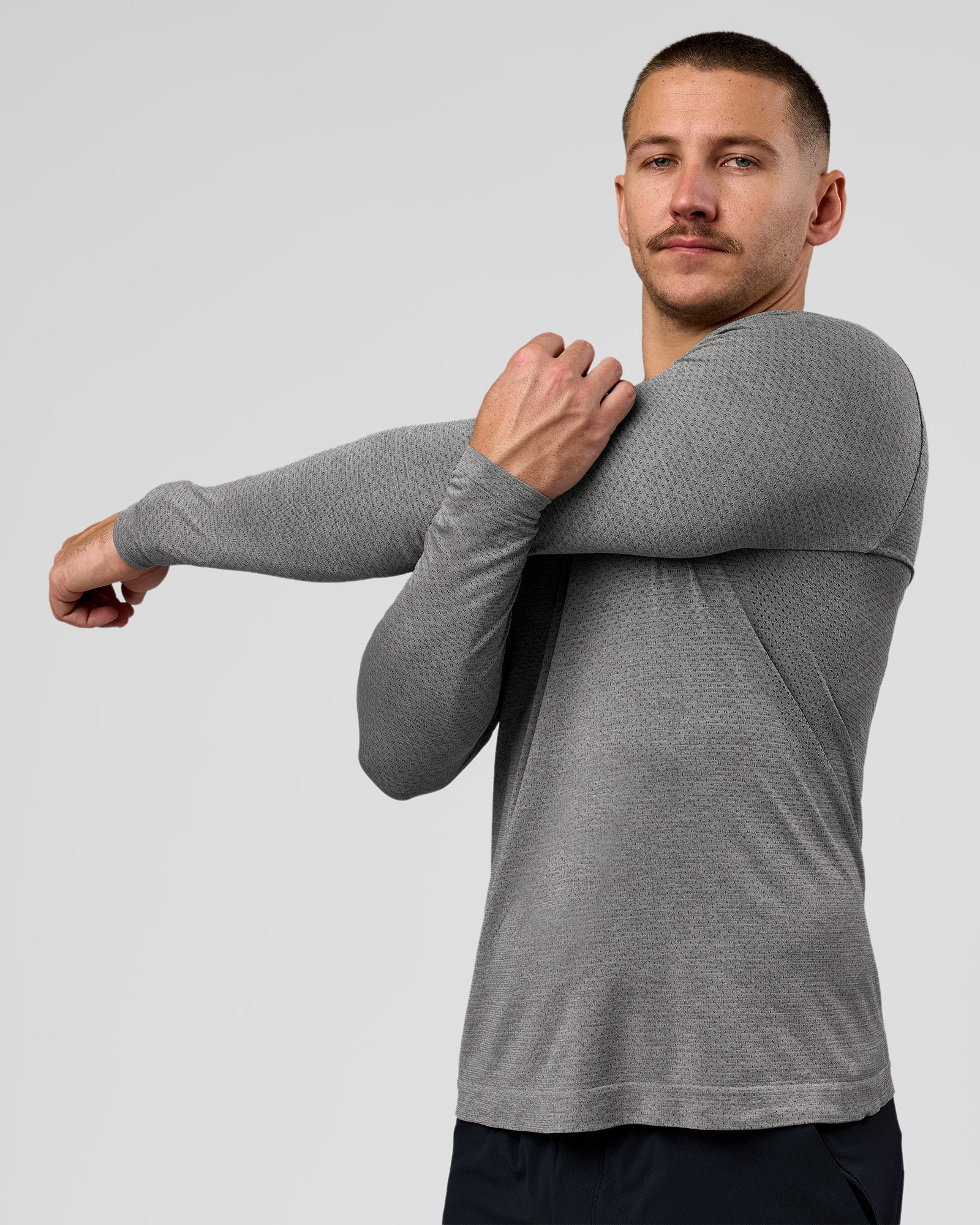 Man wearing AeroFLX+ Seamless Long Sleeve Tee (Set in Sleeve) - Dark Storm/Alloy | Model:Jaiden | Size:L