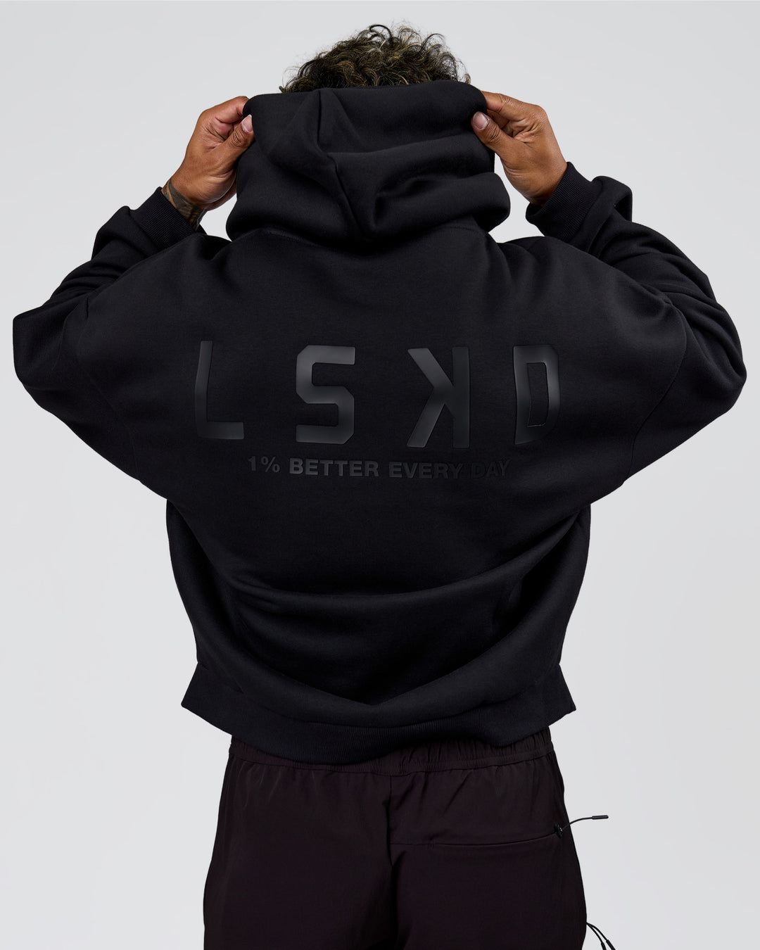 Man wearing Tonal Legacy Boxy Hoodie - Black-Black | Model:Xav | Size:L - view 2