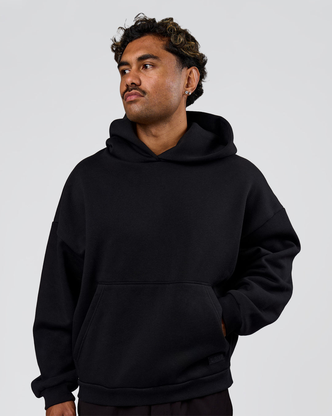 Man wearing Tonal Legacy Boxy Hoodie - Black-Black | Model:Xav | Size:L - view 5