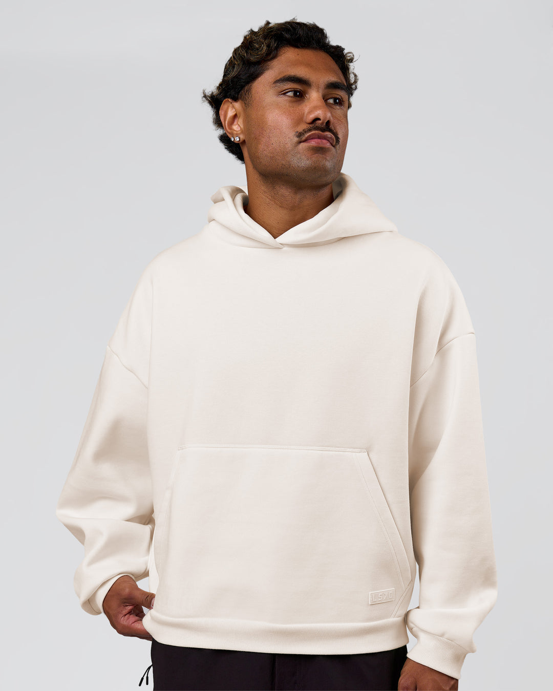 Man wearing Tonal Legacy Boxy Hoodie - Off White-Off White | Model:Xav | Size:L - view 5