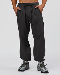 Man wearing Base Baggy Cuffed Track Pant - Onyx | Model:Albert | Size:M | Thumbnail Index: 1