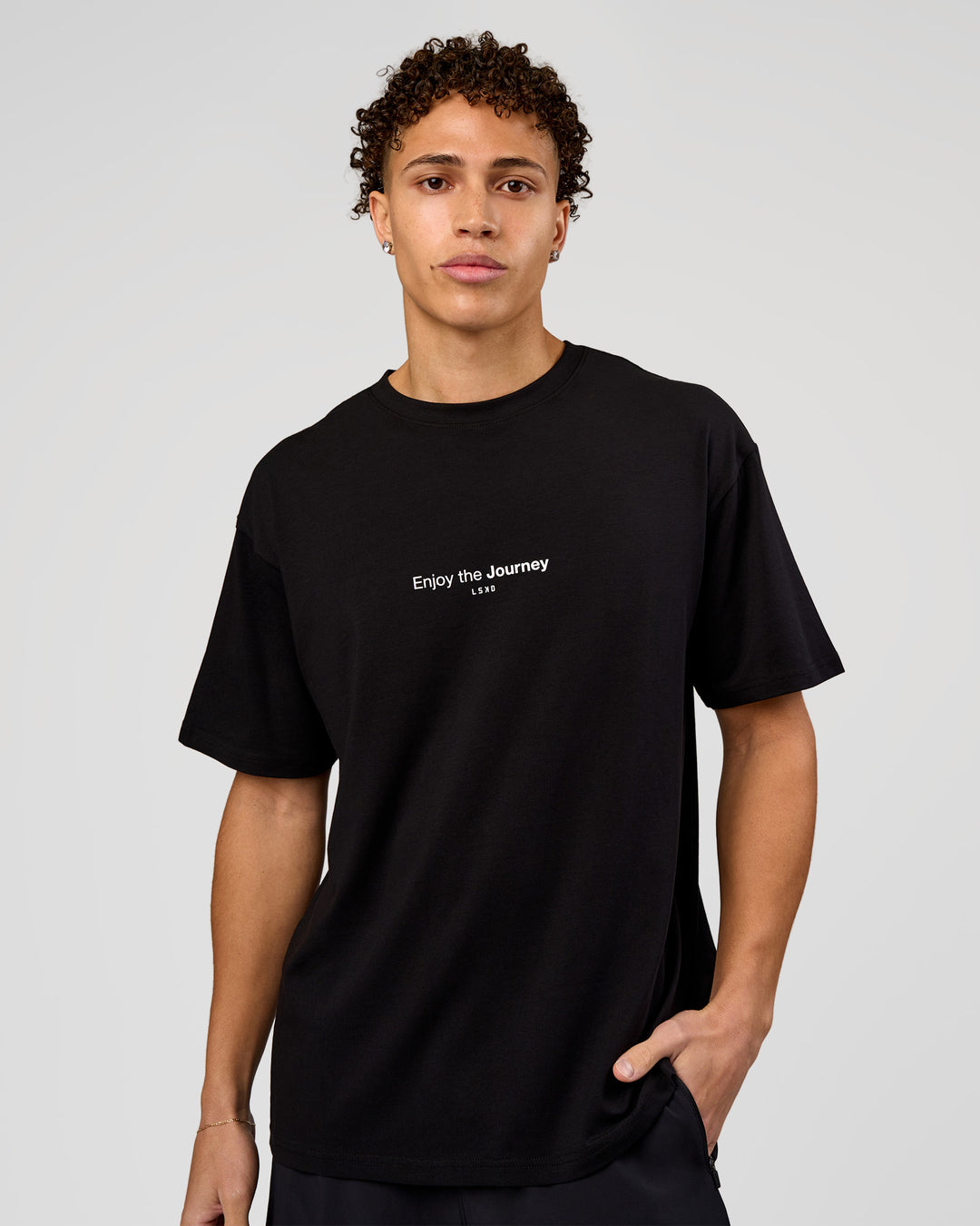 Man wearing VS1 Enjoy The Journey FLXCotton Oversize Tee - Black | Model:Leandro | Size:M - view 3