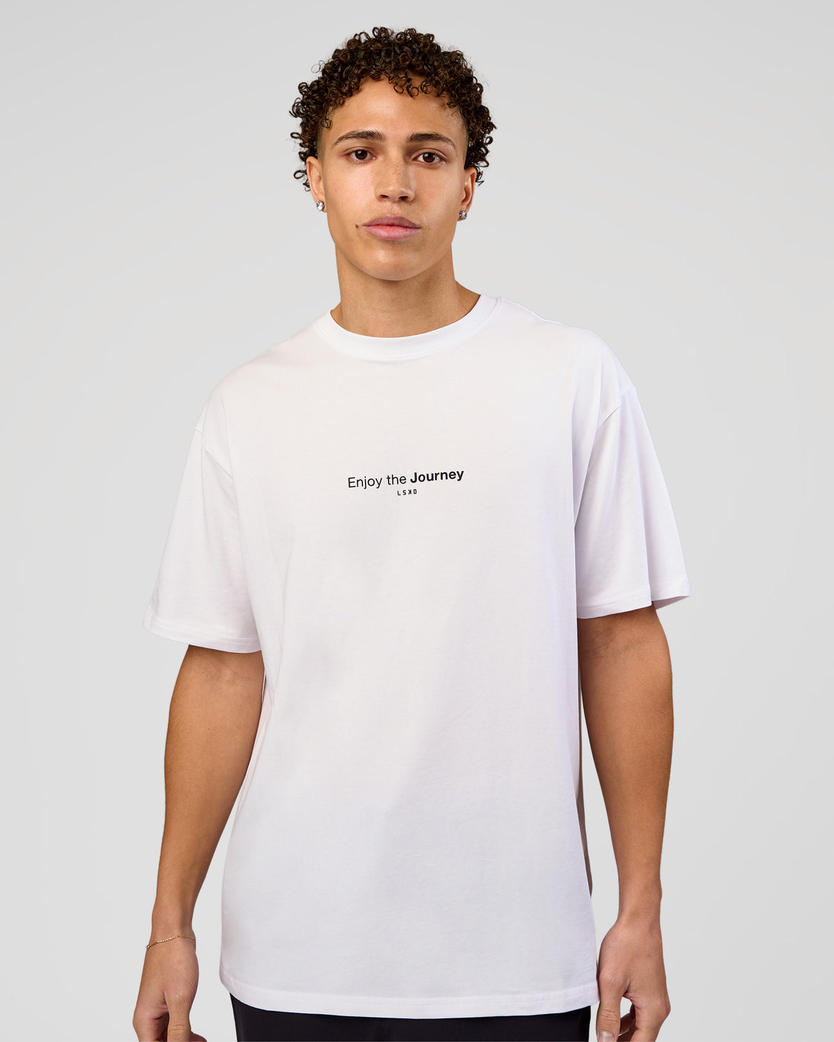 Man wearing VS1 Enjoy The Journey FLXCotton Oversize Tee - White | Model:Leandro | Size:M