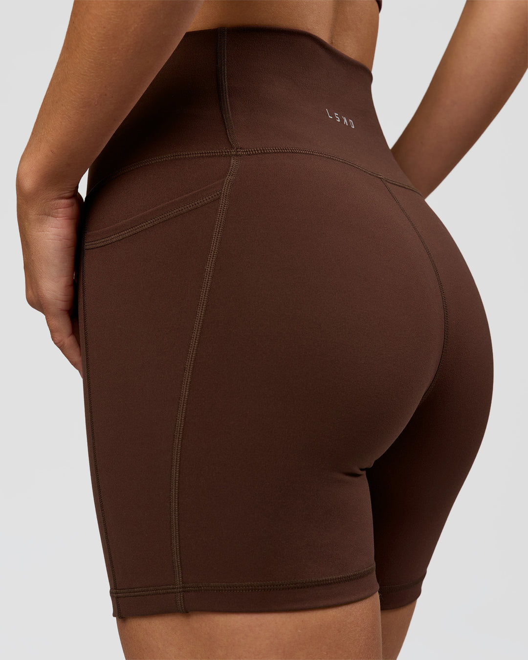 Woman wearing O.G. Fusion Ultra High-Rise 6" Short Pockets - Hot Chocolate | Model:Amity | Size:S - view 2