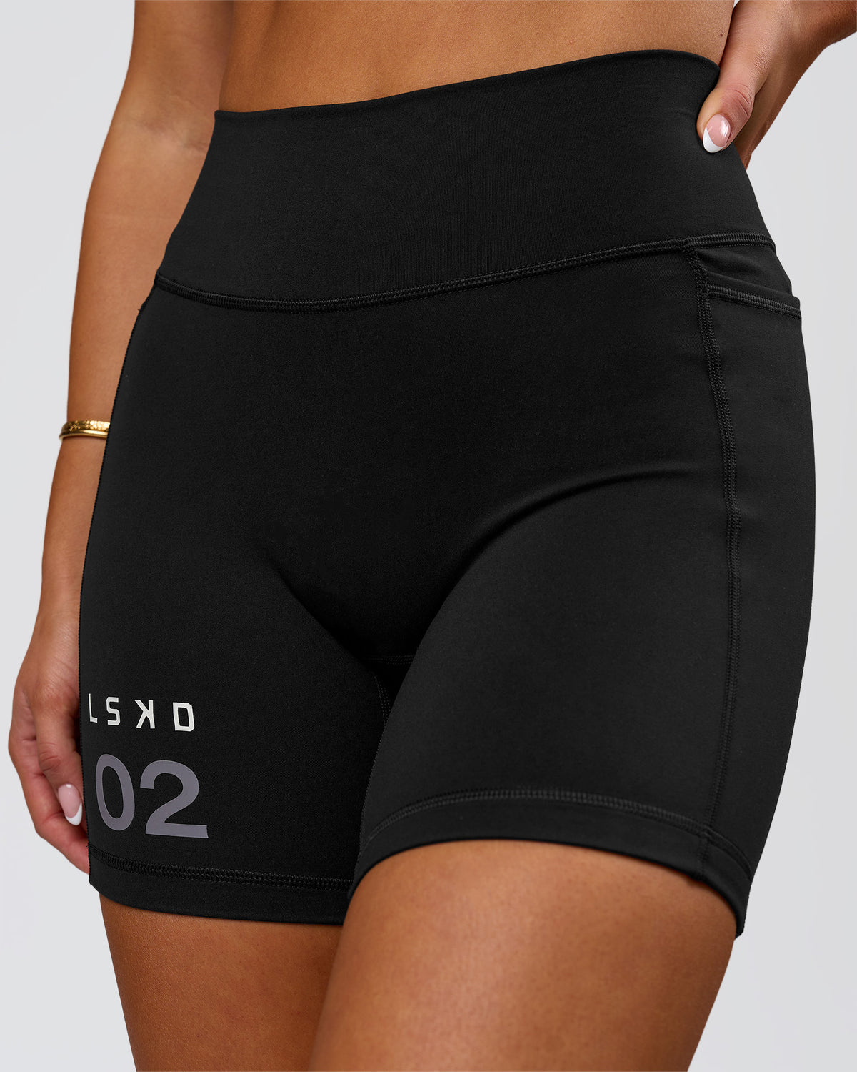 Woman wearing Fusion V-Contour High-Rise 6" Short Pockets - Black-Tech Department | Model:Bianca | Size:S