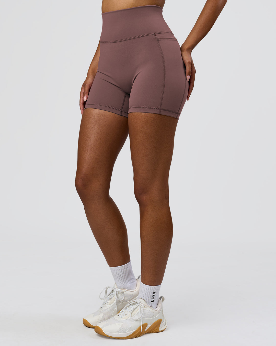 Woman wearing Fusion V-Contour Ultra High-Rise 4" Short Pockets - Cocoa Powder | Model:Jordan | Size:S - view 5