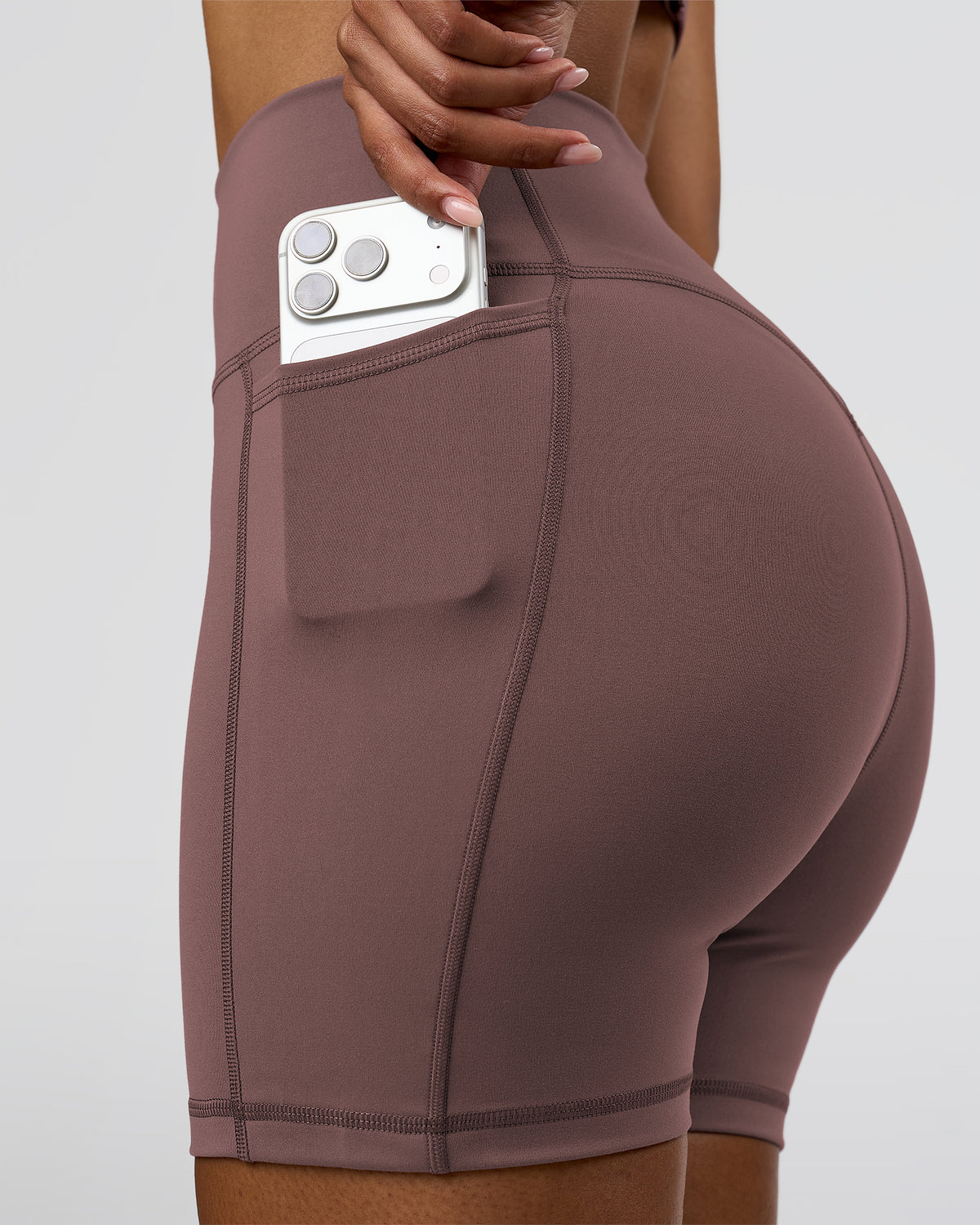 Woman wearing Fusion V-Contour Ultra High-Rise 6" Short Pockets - Cocoa Powder | Model:Jordan | Size:S - view 1