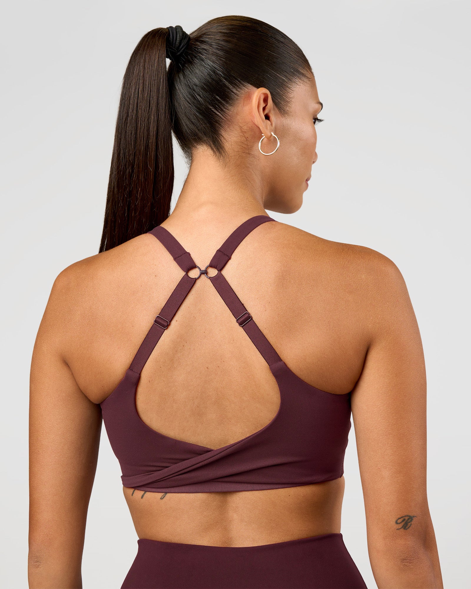 Woman wearing Twist Sports Bra D/DD/E - Cherry Lacquer | Model:Rhiley | Size:S