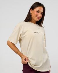 Woman wearing VS1 Enjoy The Journey FLXCotton Oversize Tee - Vanilla Bean | Model:Bianca | Size:XS | Thumbnail Index: 2