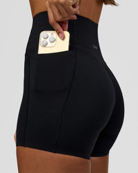 Woman wearing Fusion Bonded High-Rise 4" Short Pockets - Black | Model:Brylee | Size:XS | Thumbnail Index: 1