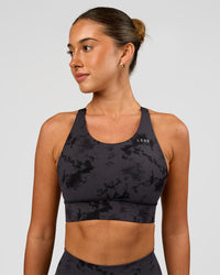 Woman wearing Accelerate Split Strap Sports Bra - Black Tie Dye | Model:Charli | Size:XS | Thumbnail Index: 1