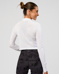 Woman wearing AeroFLX+ Long Sleeve Skimmer Half Zip - White/White | Model:Charli | Size:XS | Thumbnail Index: 1