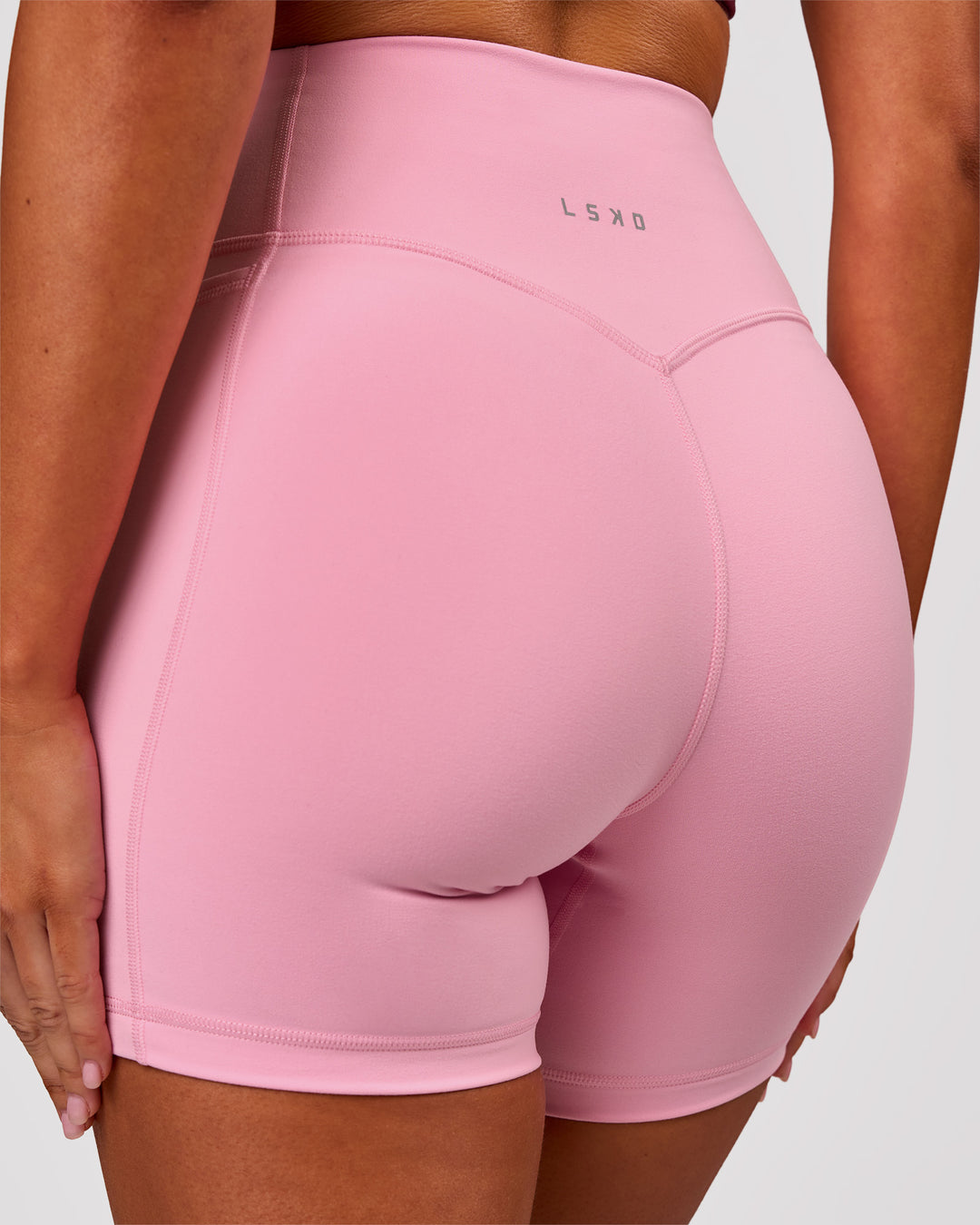 Woman wearing Fusion V-Contour Ultra High-Rise 6" Short Pockets - Pink Rose | Model:Charli | Size:XS - view 1