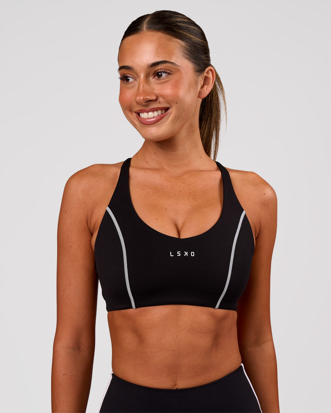 Woman wearing Stellar Sports Bra - Black-White | Model:Charli | Size:XS - view 2
