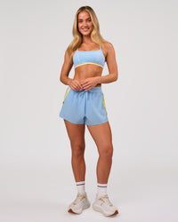 Woman wearing Accelerate 3" Force High-Rise Running Short - Open Air-Lemon | Model:Issy | Size:XS | Thumbnail Index: 7