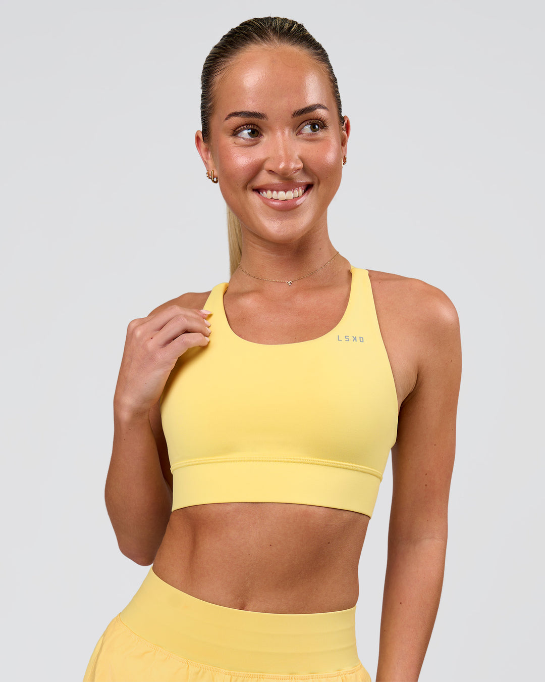 Woman wearing Accelerate Sports Bra - Lemon | Model:Issy | Size:XS - view 1