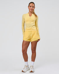 Woman wearing AeroFLX+ Long Sleeve Half Zip - Lemon/Lemon | Model:Issy | Size:XS | Thumbnail Index: 1