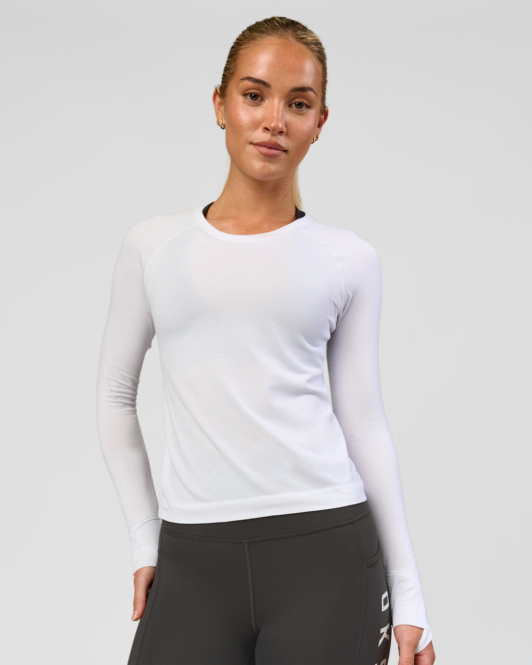 Woman wearing AeroFLX+ Seamless Long Sleeve Tee - White/White | Model:Issy | Size:XS - view 1