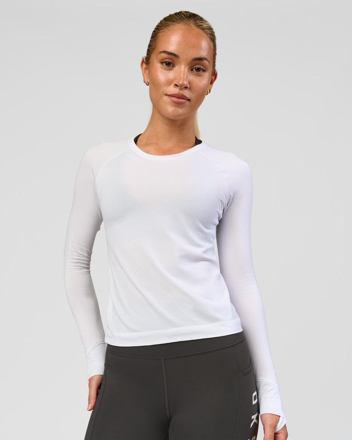 Woman wearing AeroFLX+ Seamless Long Sleeve Tee - White/White | Model:Issy | Size:XS