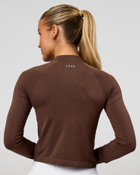 Woman wearing AeroFLX+ Long Sleeve Skimmer Half Zip - Hot Chocolate/Hot Chocolate | Model:Issy | Size:XS | Thumbnail Index: 2